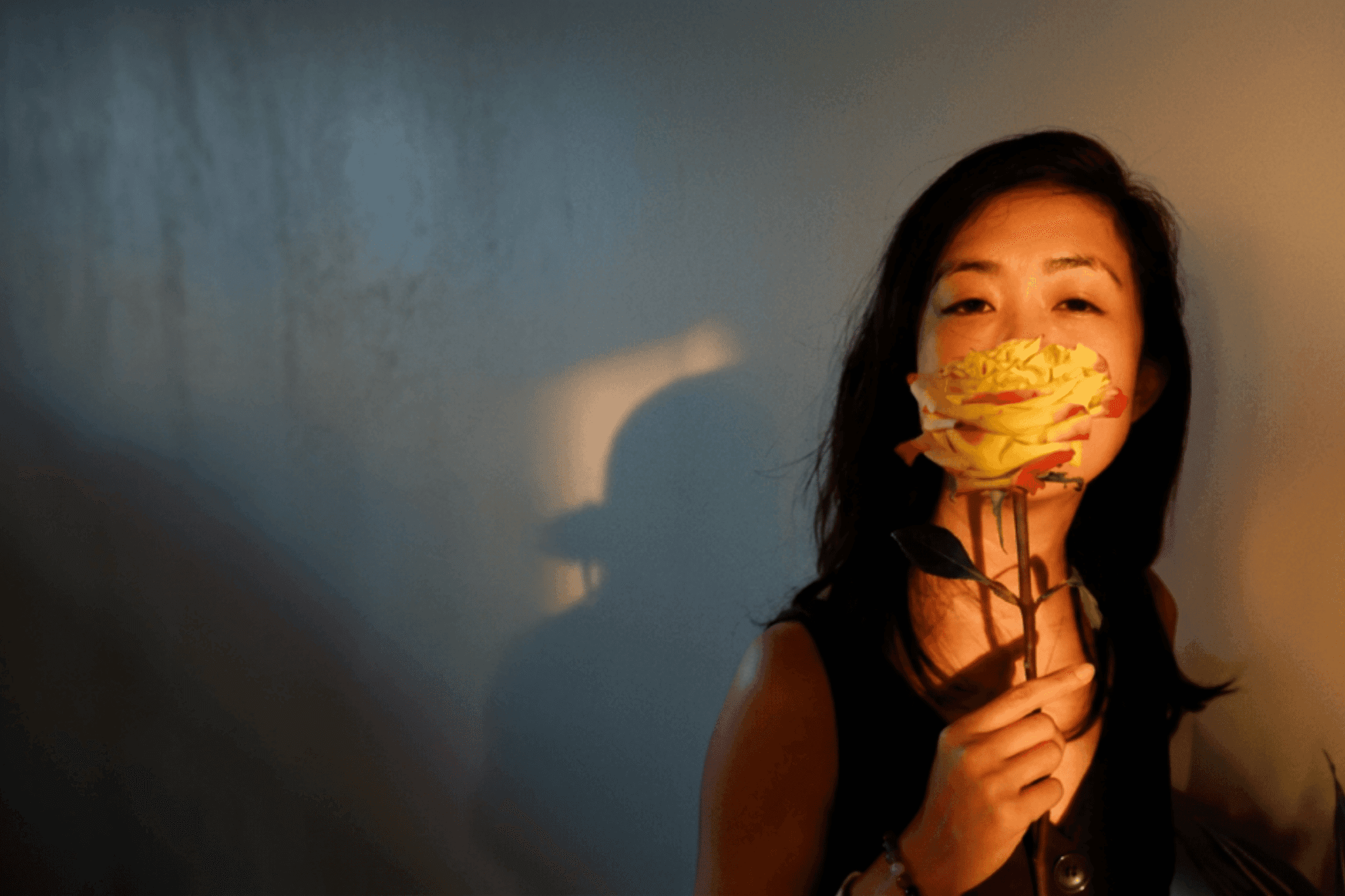 Thea L. Custodio holding a rose in warm afternoon light